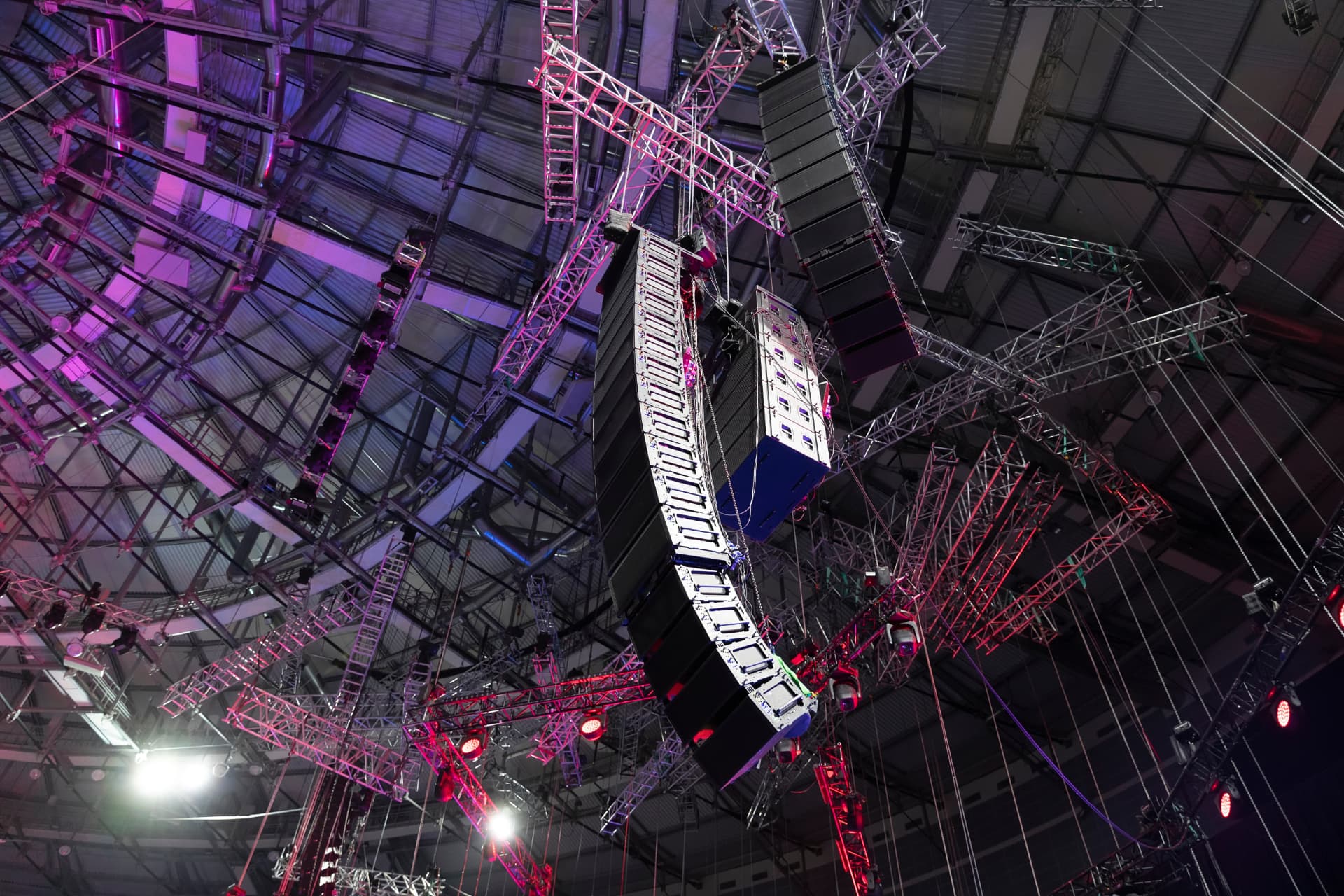 Line array speakers and lighting truss rigged above an arena stage